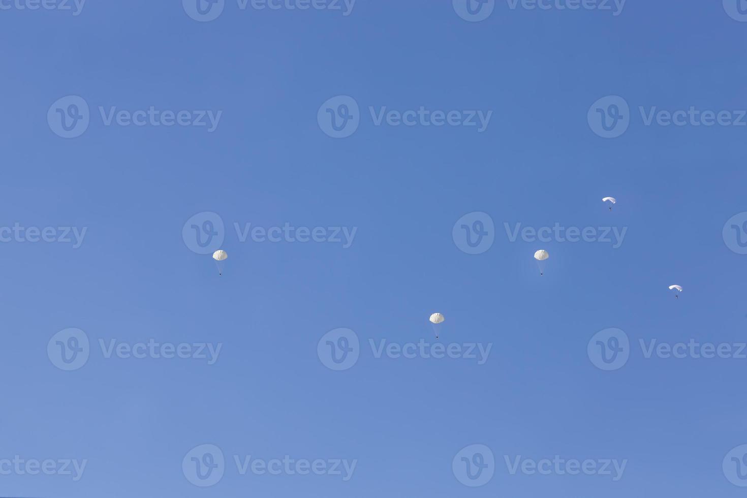 skydivers descending in the blue sky photo