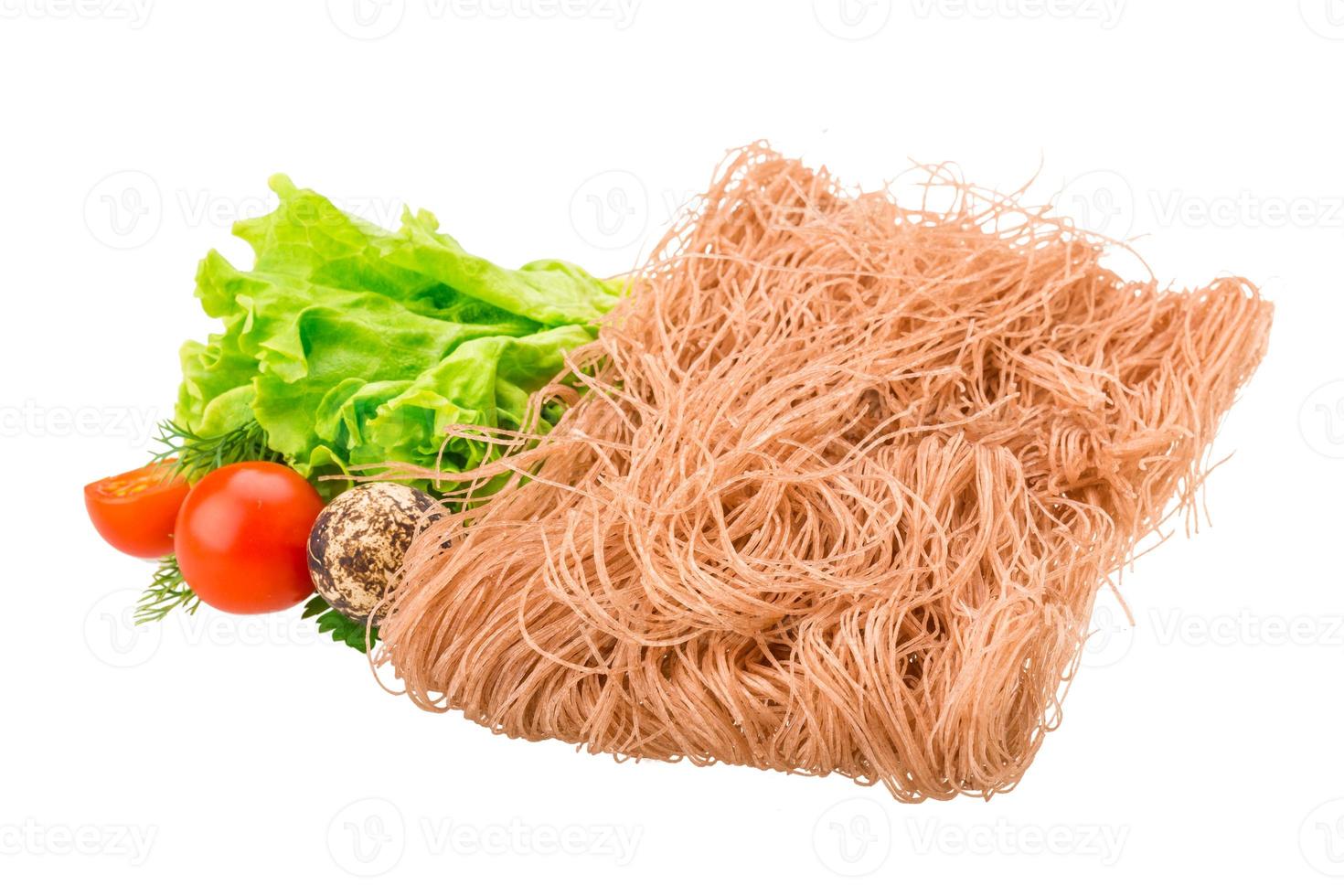 fideos de arroz crudo sobre fondo blanco foto