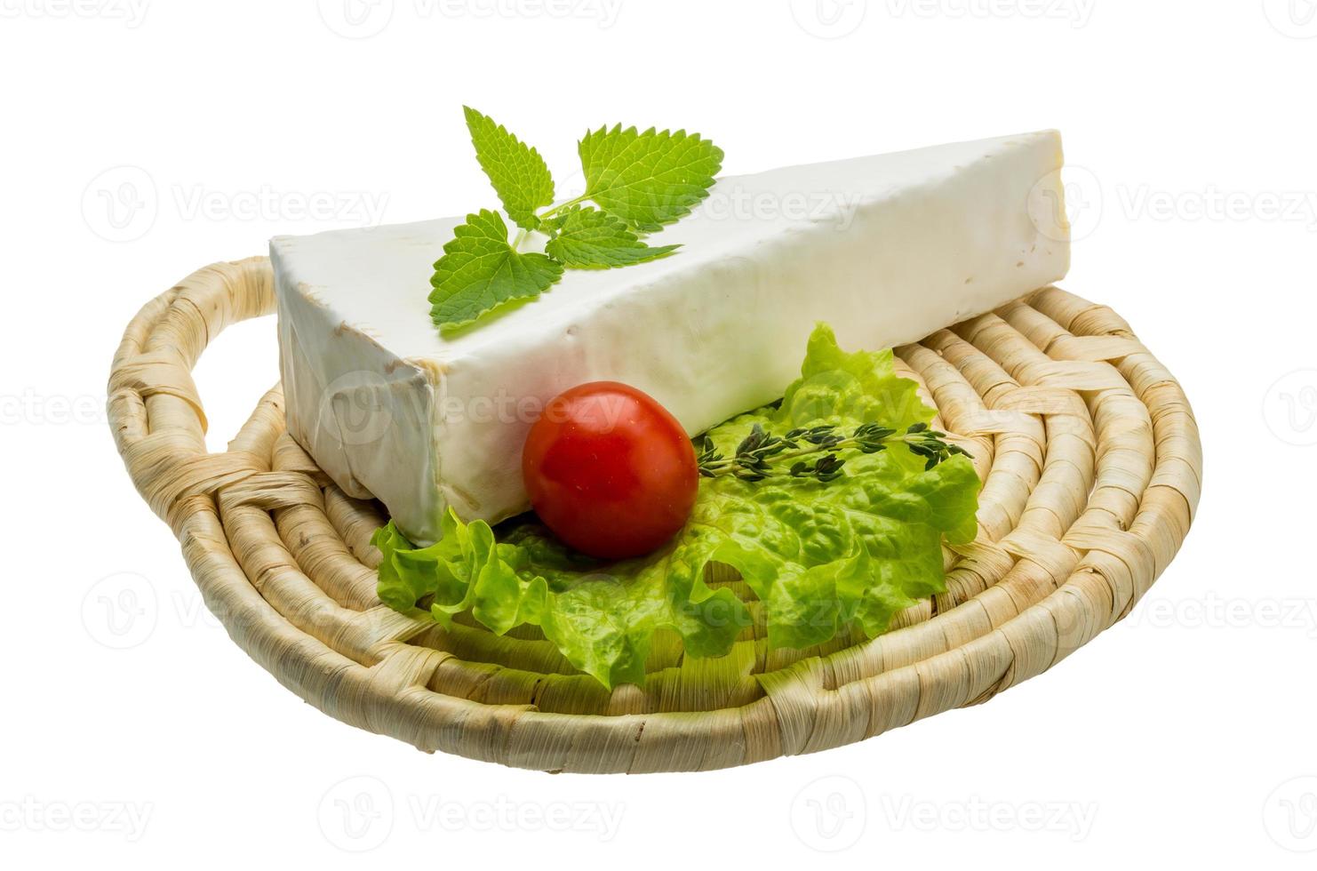Brie cheese with thyme on wooden plate and white background photo