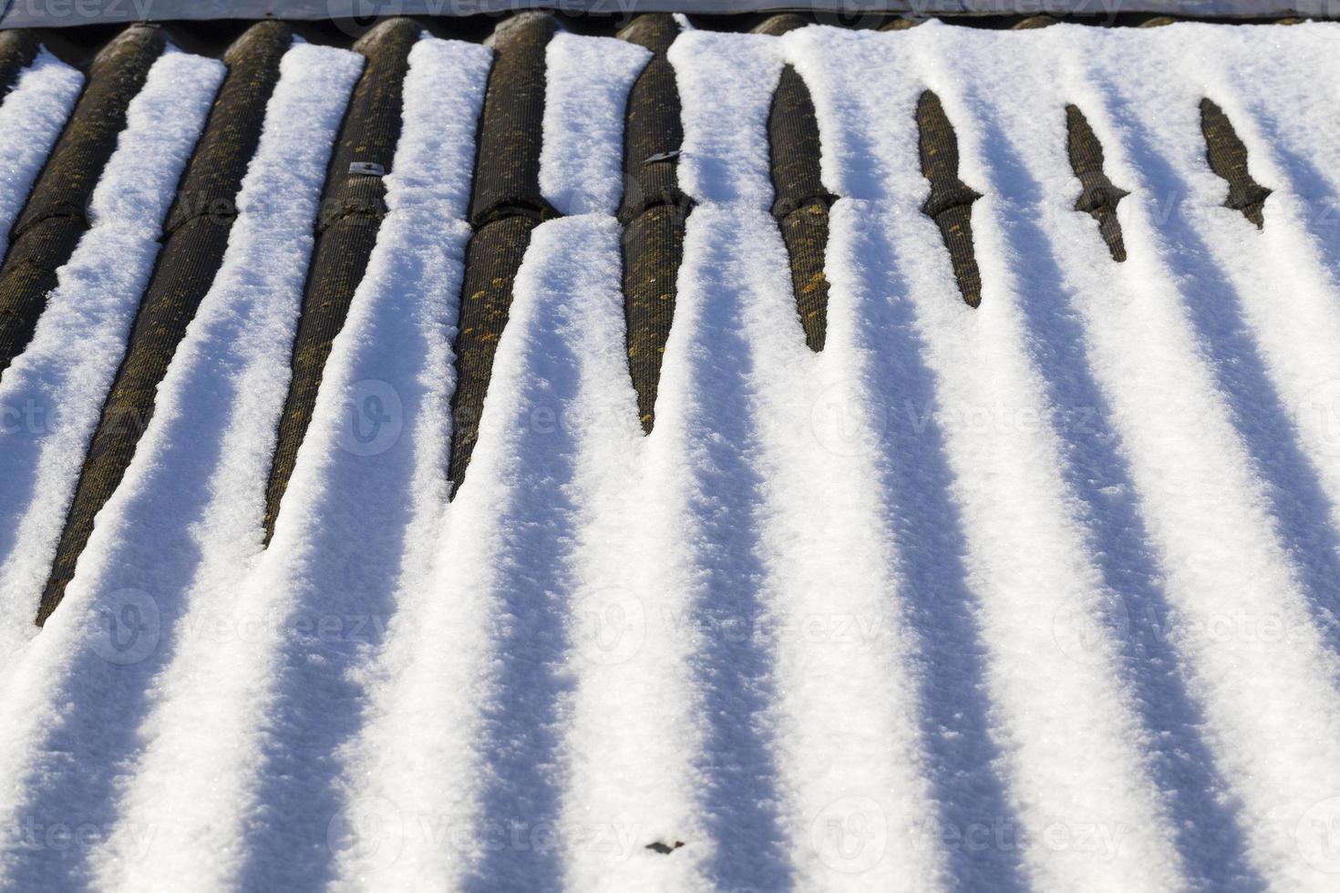 white snow on the roof of a house photo