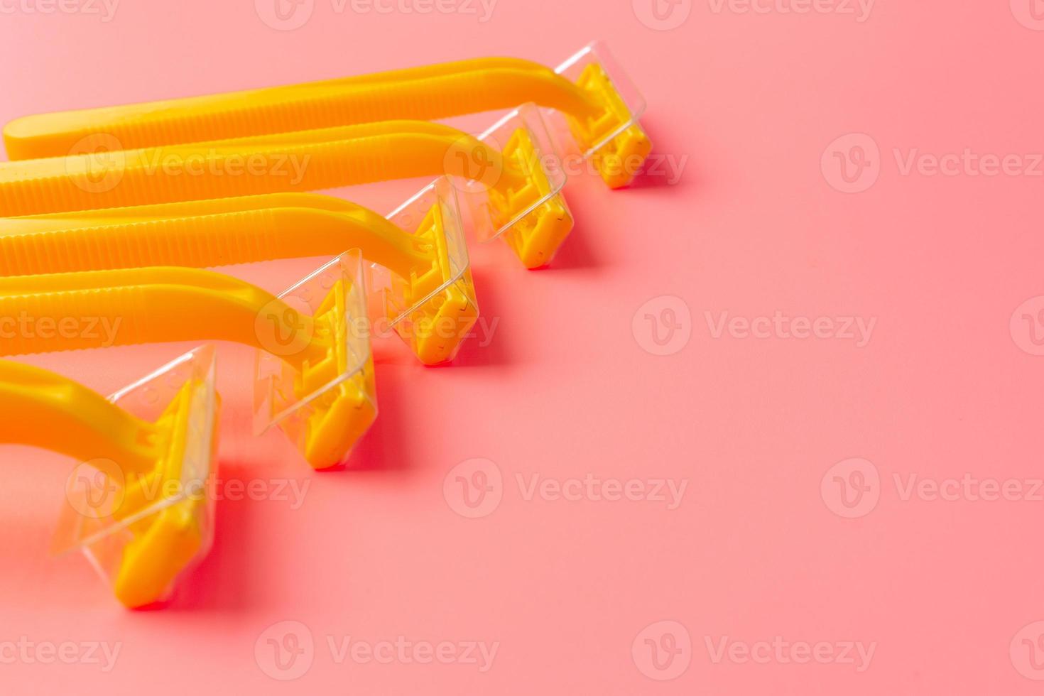 Disposable shaver on a light pink background with a copy space. photo