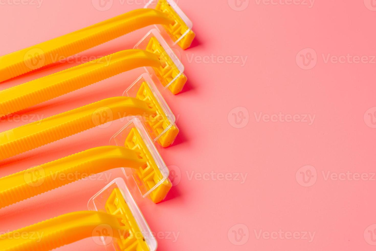 Disposable shaver on a light pink background with a copy space. photo