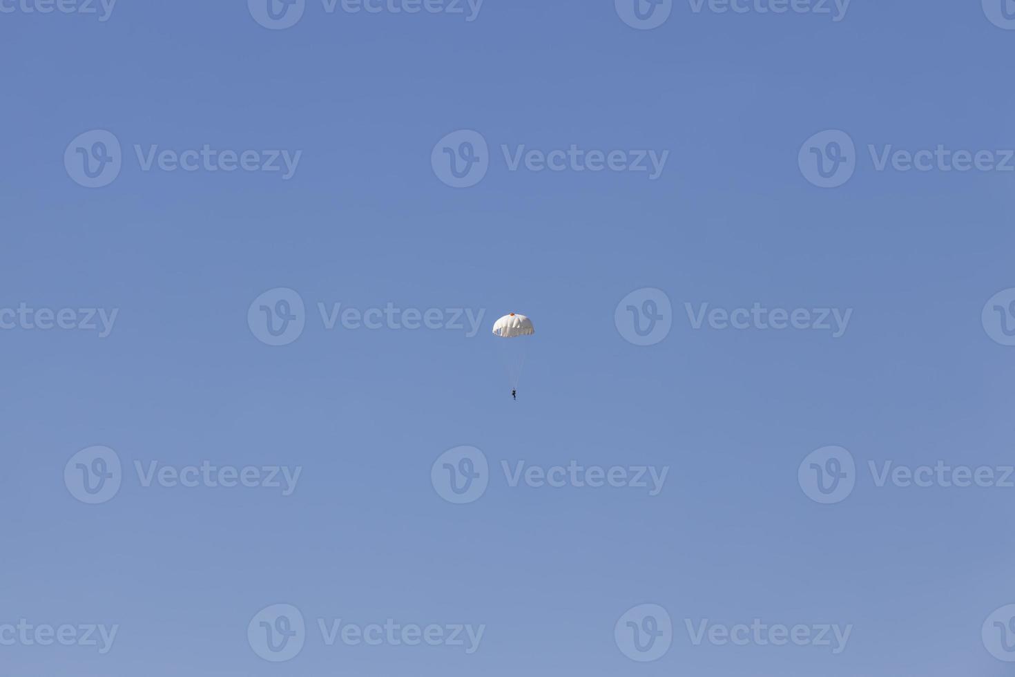 skydivers descending in the blue sky photo