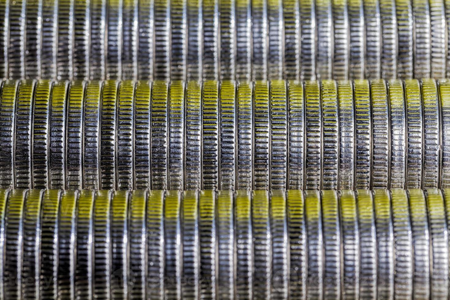 many round metal coins of silver color illuminated with Golden color photo