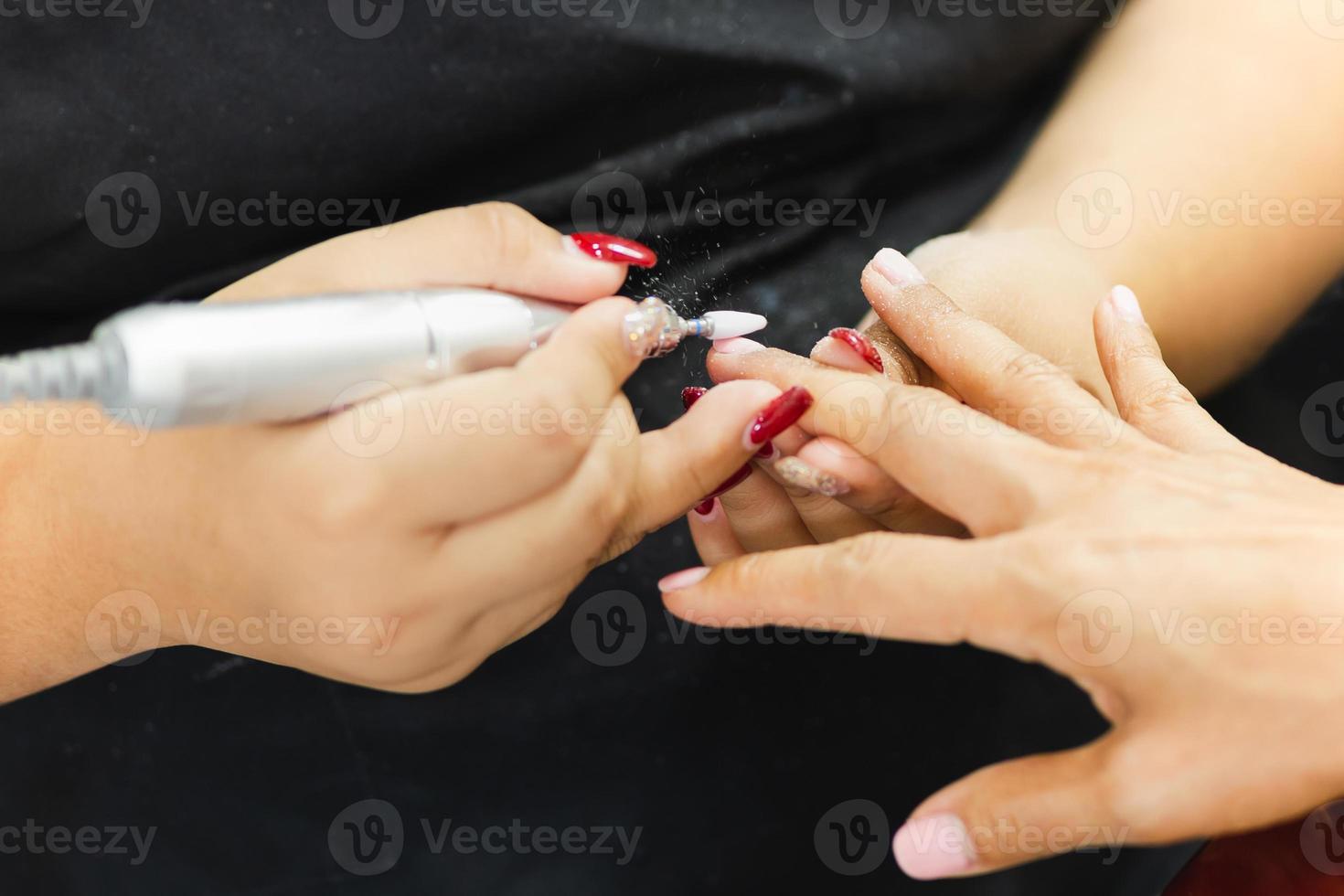 Female get professional manicure in beauty shop. photo