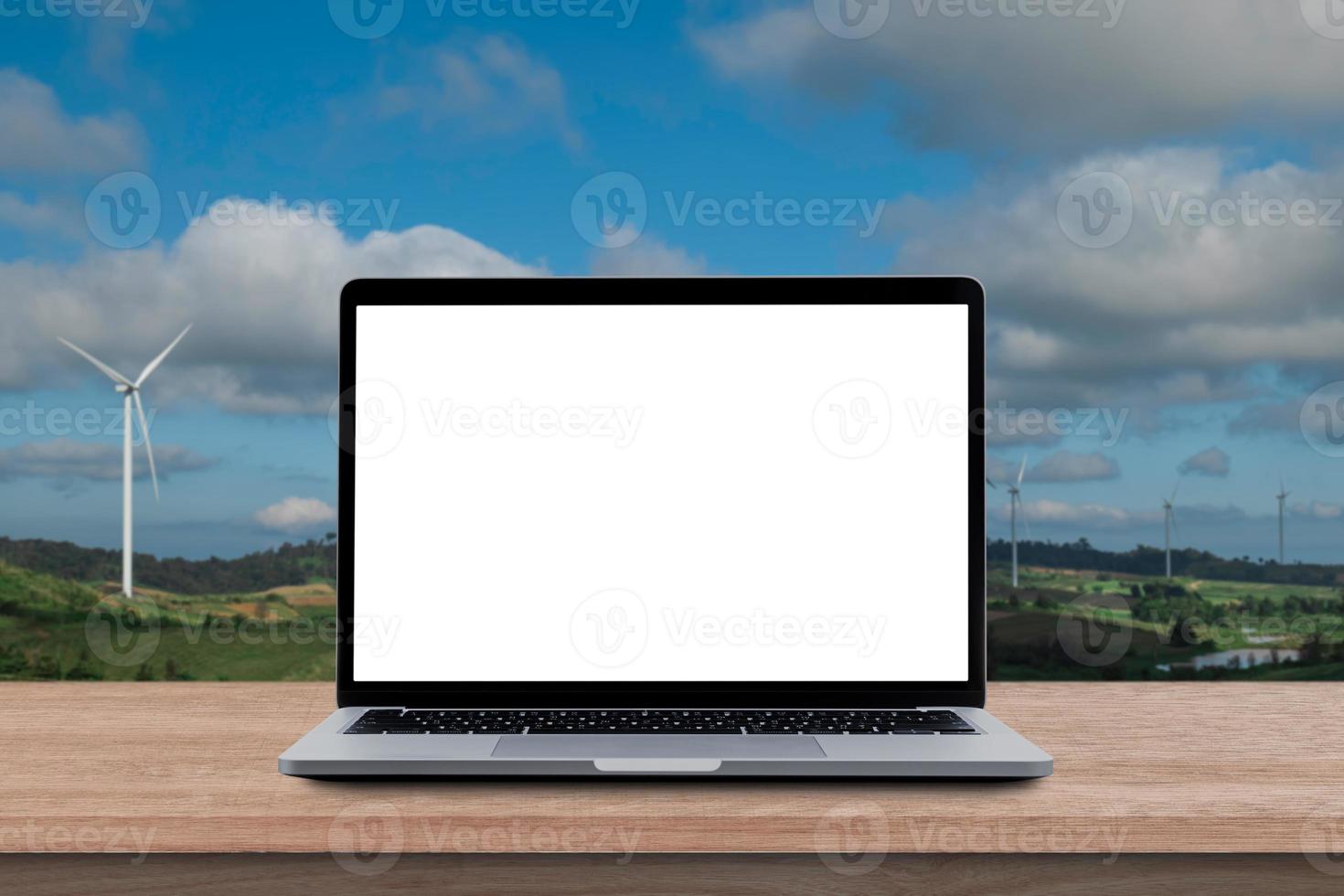 Modern Laptop computer with blank screen on wood table over mountain and sky background. photo