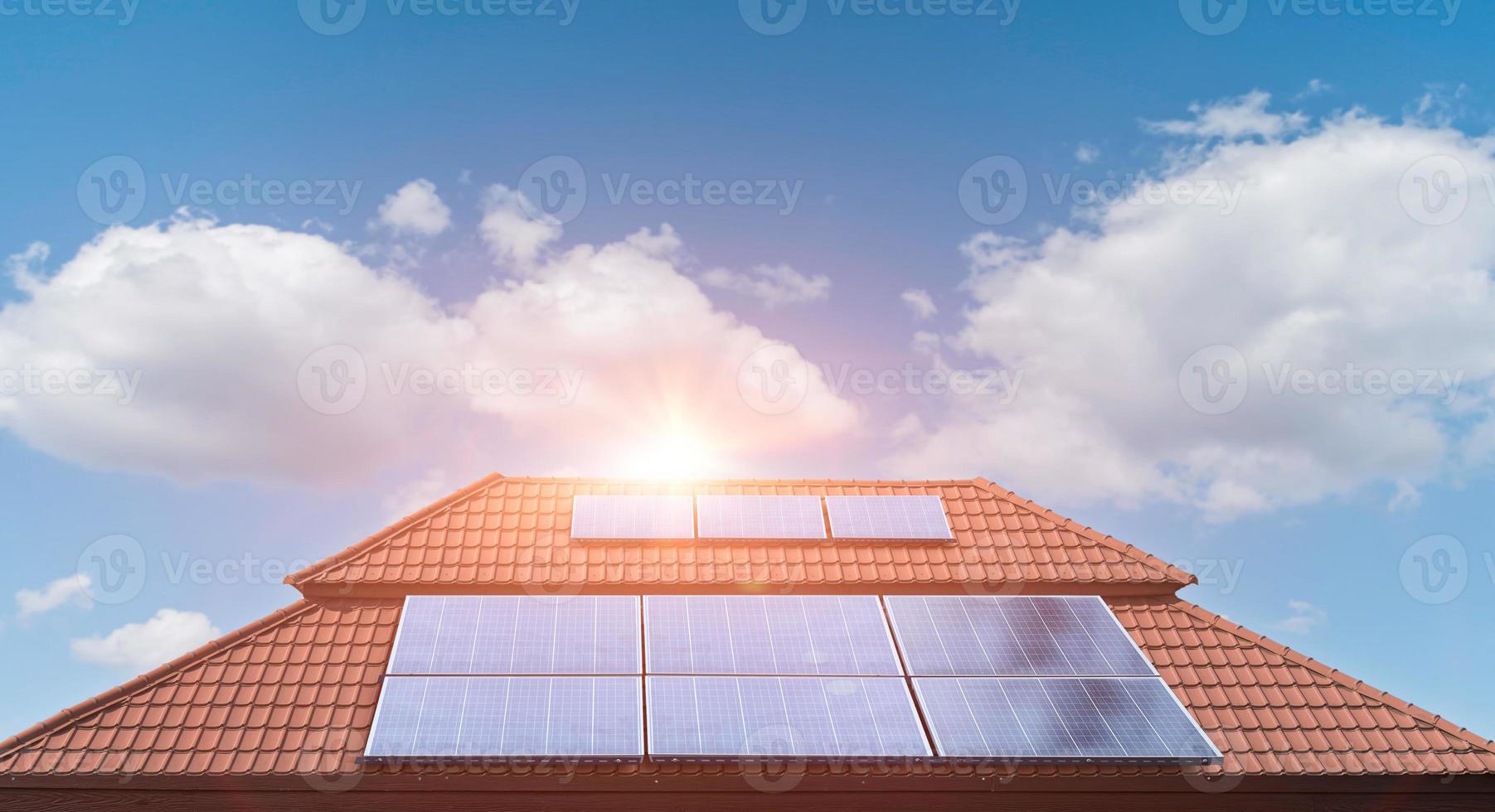 panel solar en el techo de una casa con fondo de nubes de cielo azul. foto