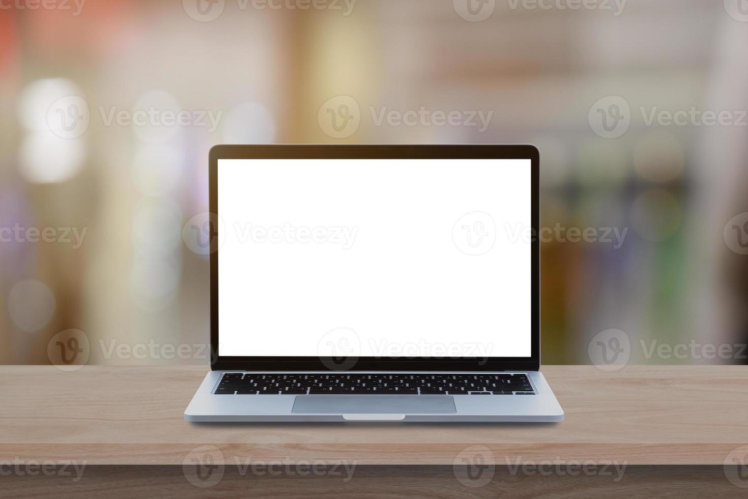 Modern Laptop computer with blank screen on wood table over blur bokeh light background. photo