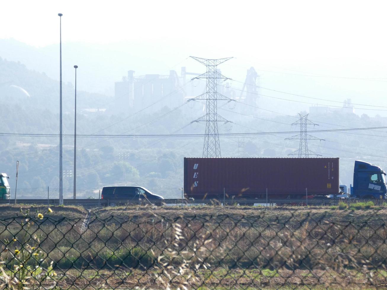 tráfico en la carretera y torres de alta tensión en el fondo foto