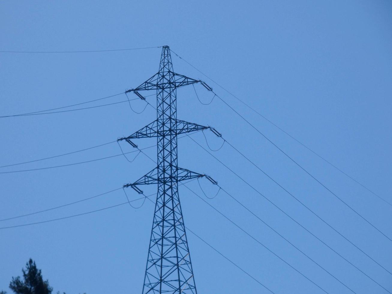 Silhouettes of high voltage metal towers in the mountains photo