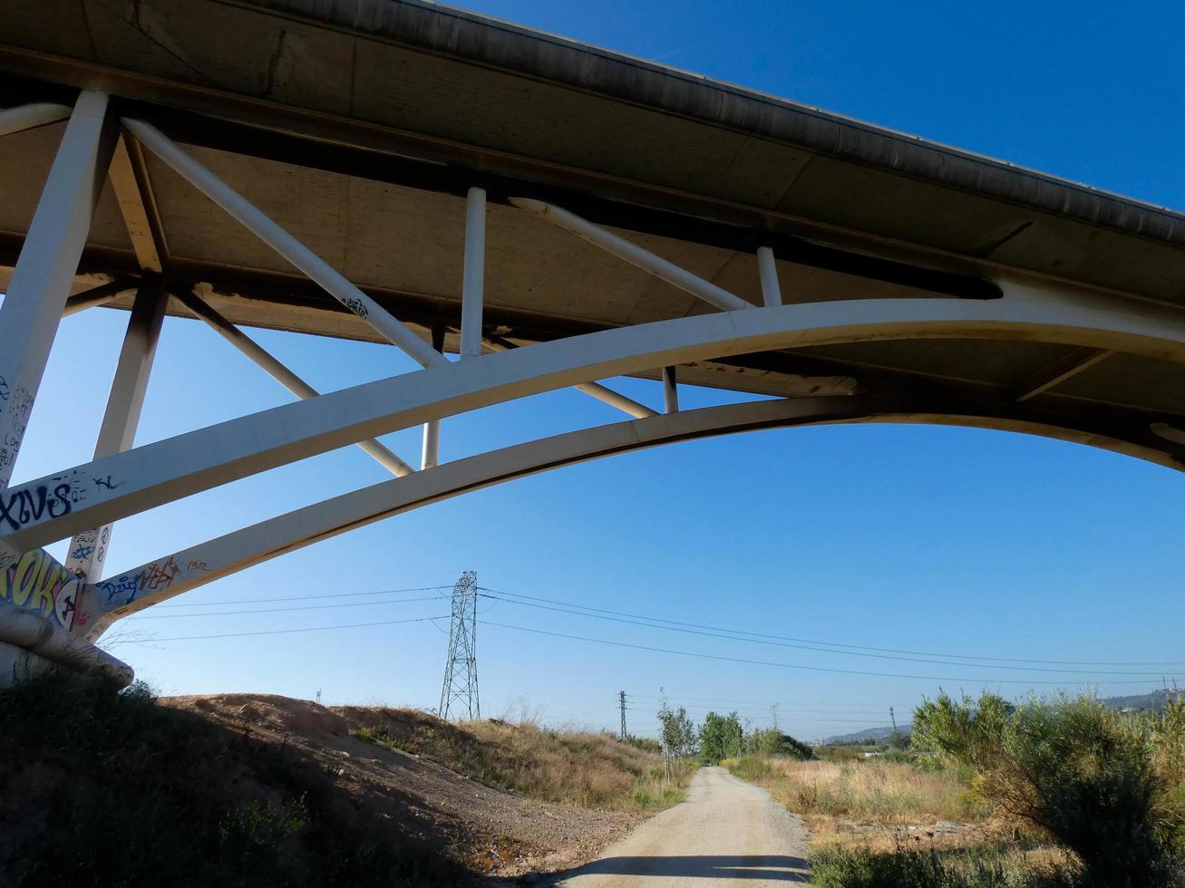 Silhouette of the arch of a modern bridge over a road photo