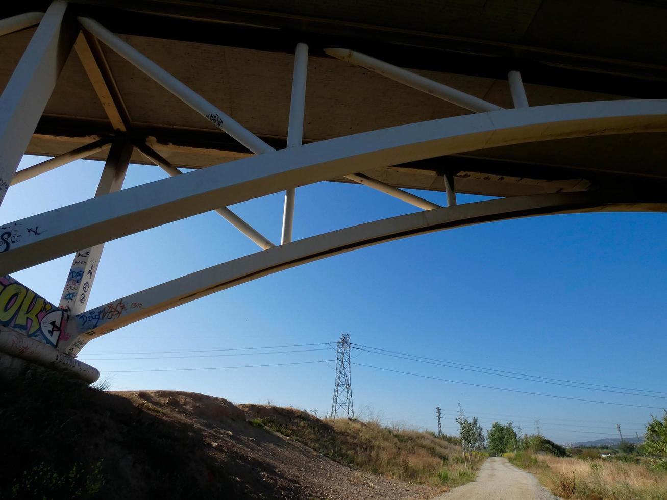 Silhouette of the arch of a modern bridge over a road photo