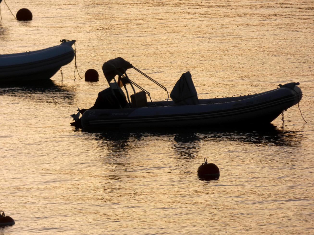 Backlighting of sport boats at anchor in a bay photo