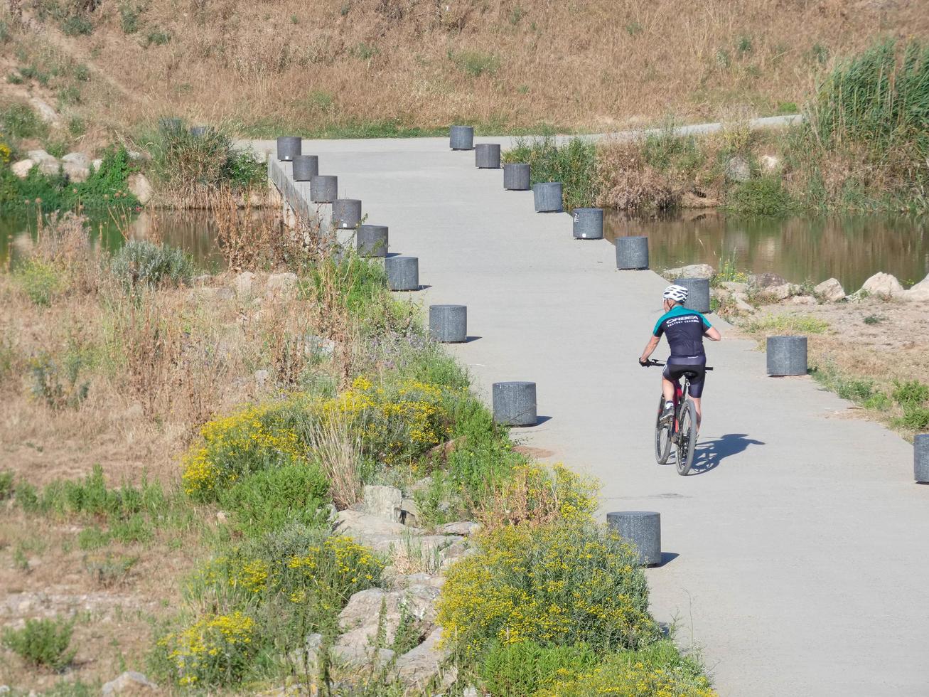 man on a bicycle crossing a flood bridge on the Llobregat river, very close to the city of Barcelona. photo