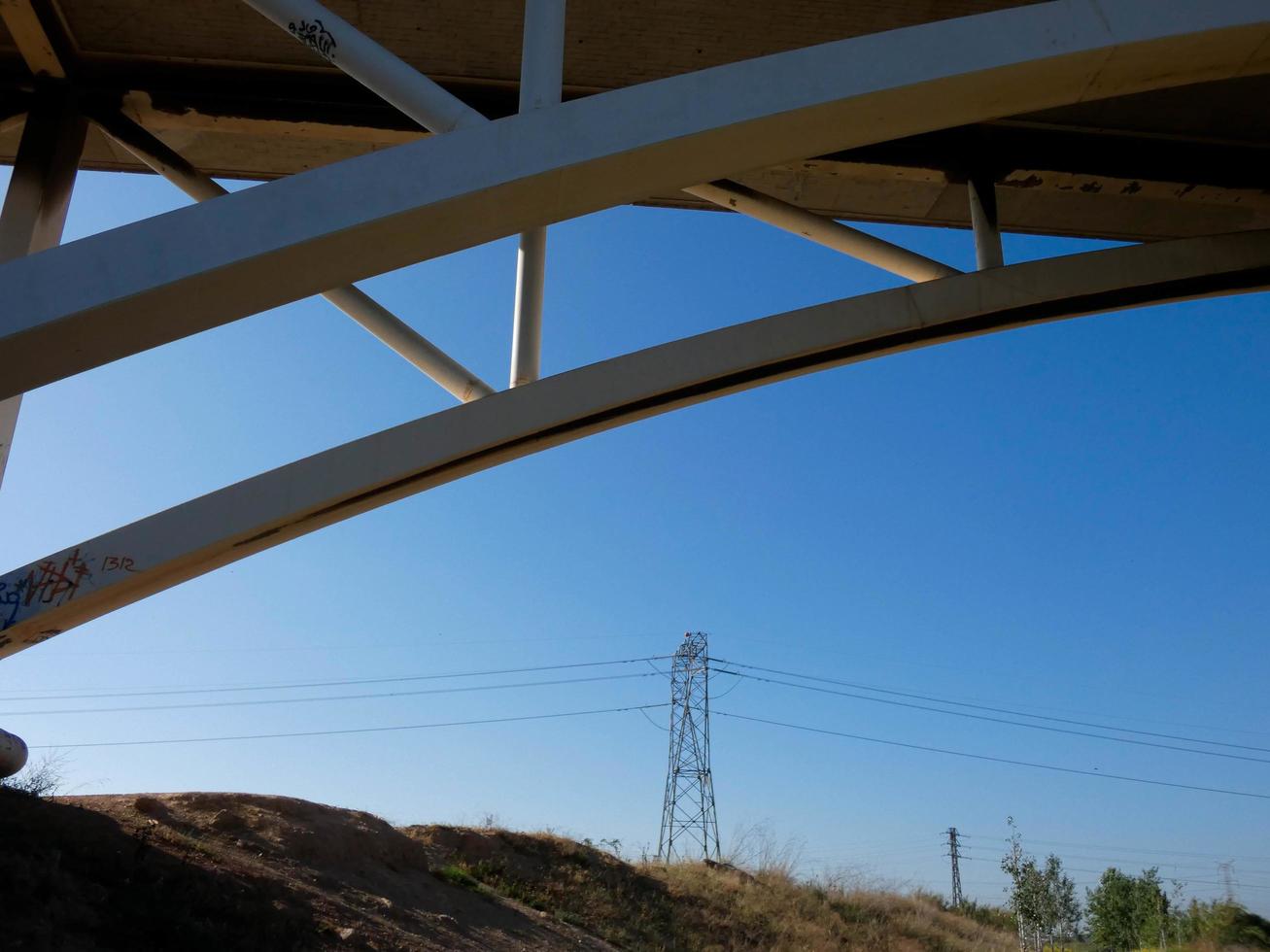 Silhouette of the arch of a modern bridge over a road photo