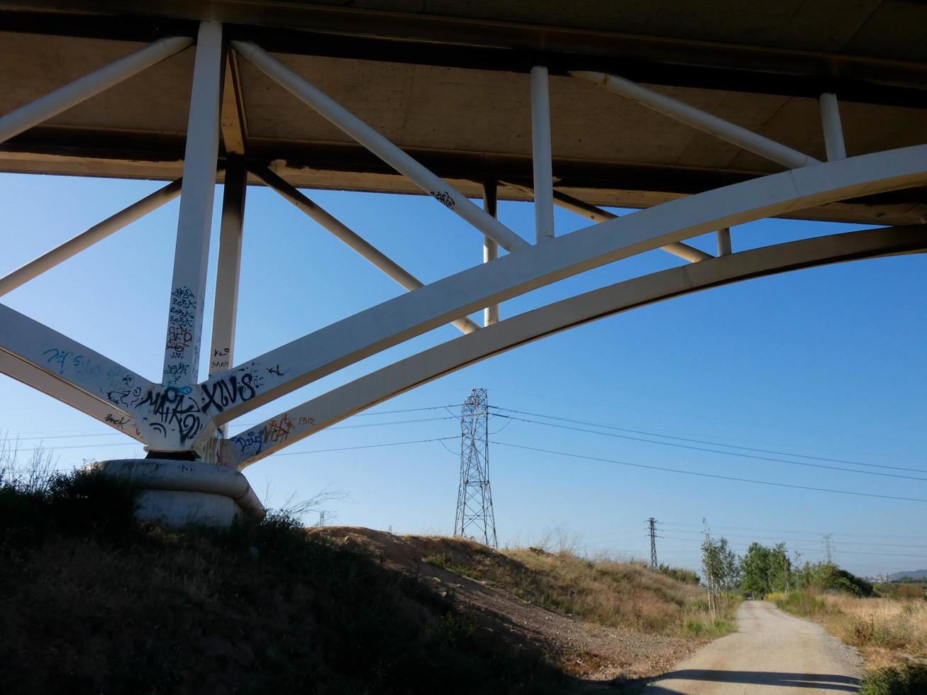 Silhouette of the arch of a modern bridge over a road photo