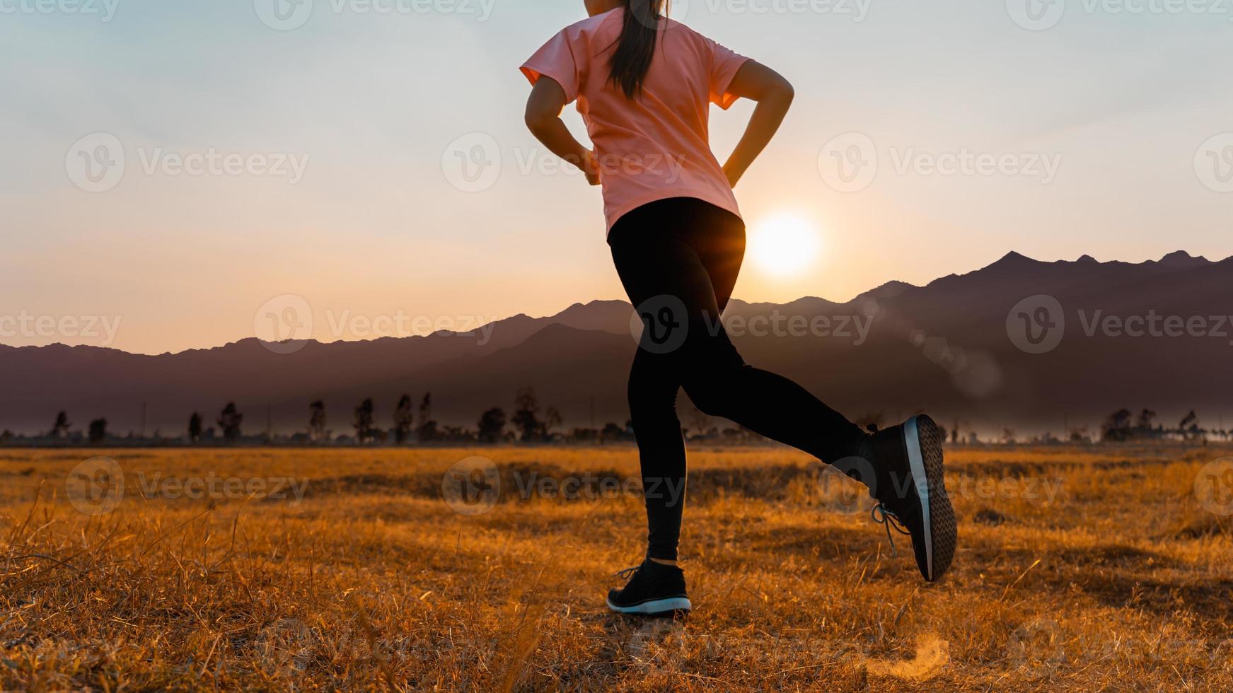 Woman enjoys running outside with beautiful summer evening in the countryside. photo