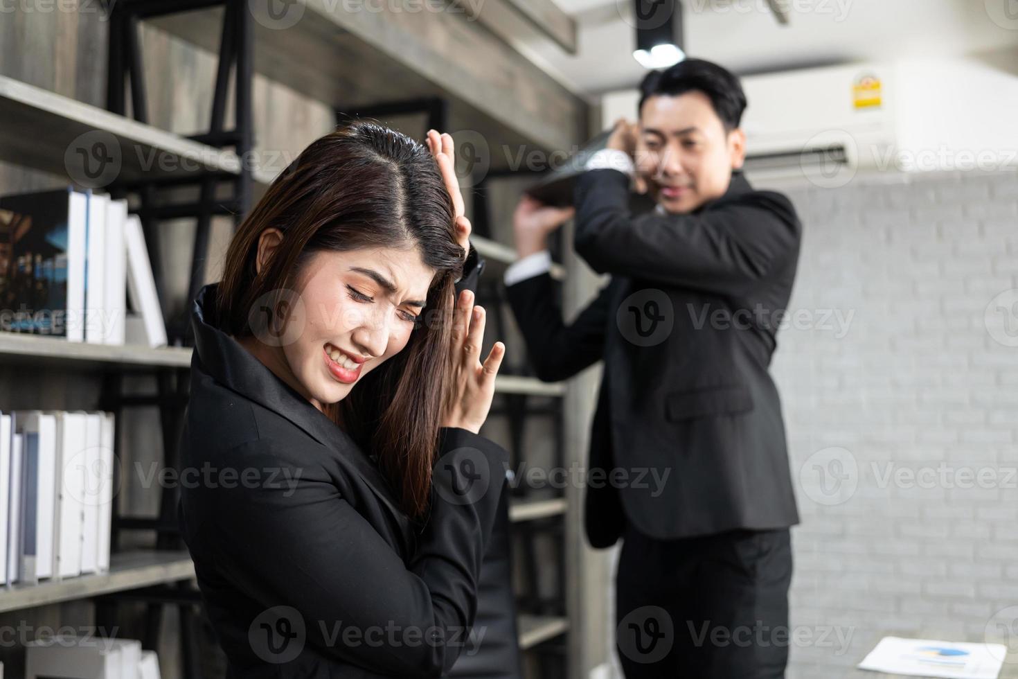 Emotional colleagues fighting in office. Workplace conflict. Angry boss. Man as a boss in the office is violent against a woman as an employee photo