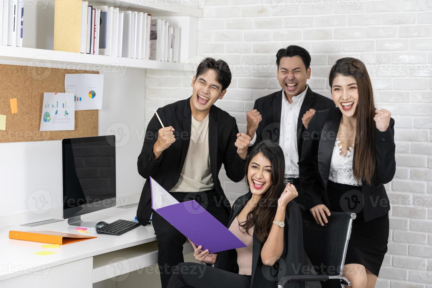 sí empresarios triunfando por el crecimiento financiero de la empresa. felices empresarios sonrientes triunfando con los puños levantados. foto