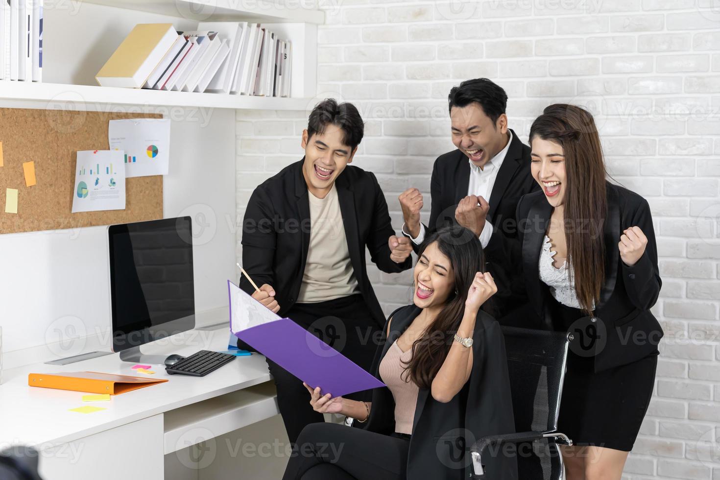 Yes Businesspeople triumphing because of the financial growth of company. Happy smiling businesspeople triumphing with raised fists. photo