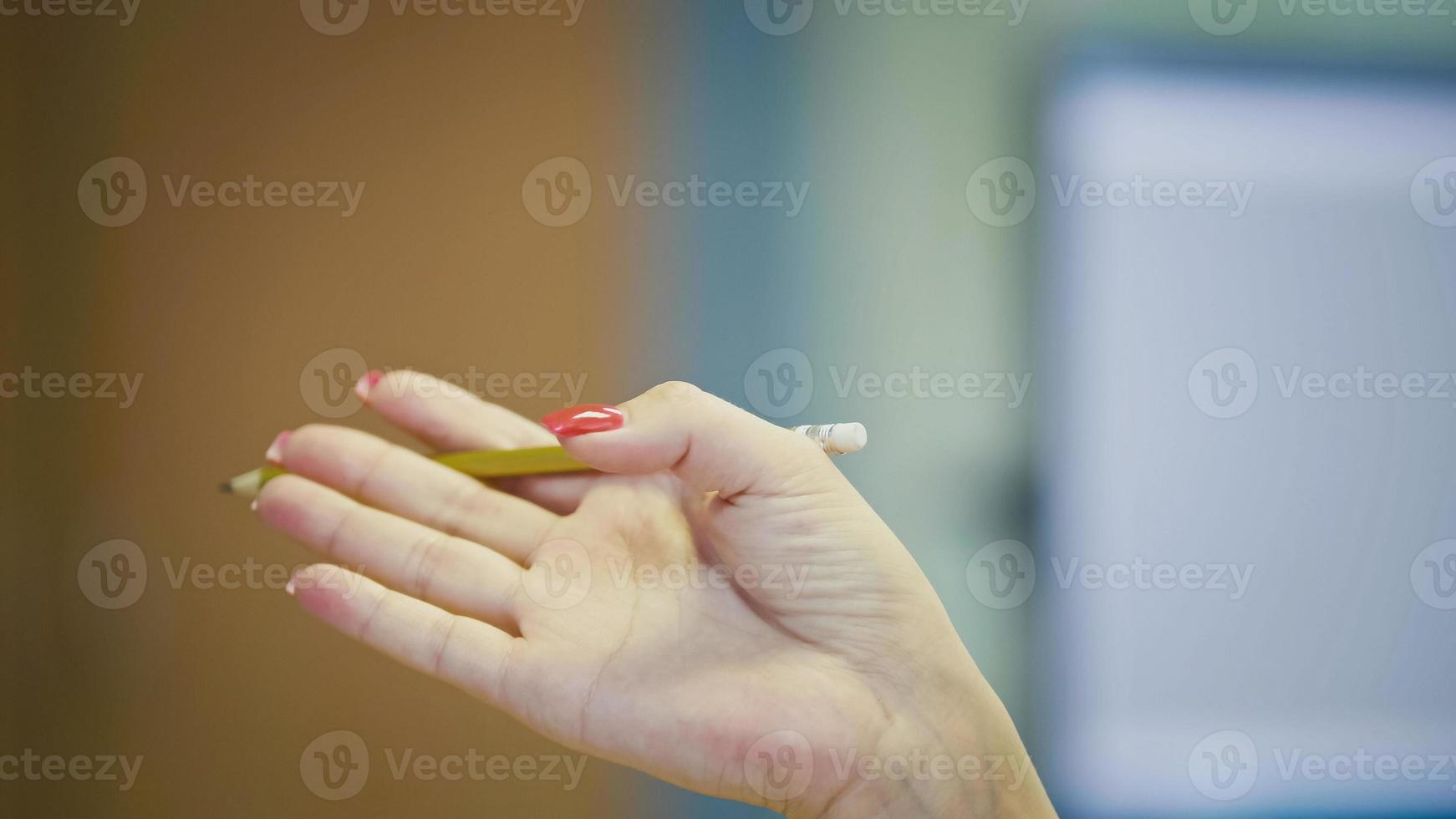 Hand gestures of Woman Office Manager when talking on the phone - manicure with bright red nails, close up photo