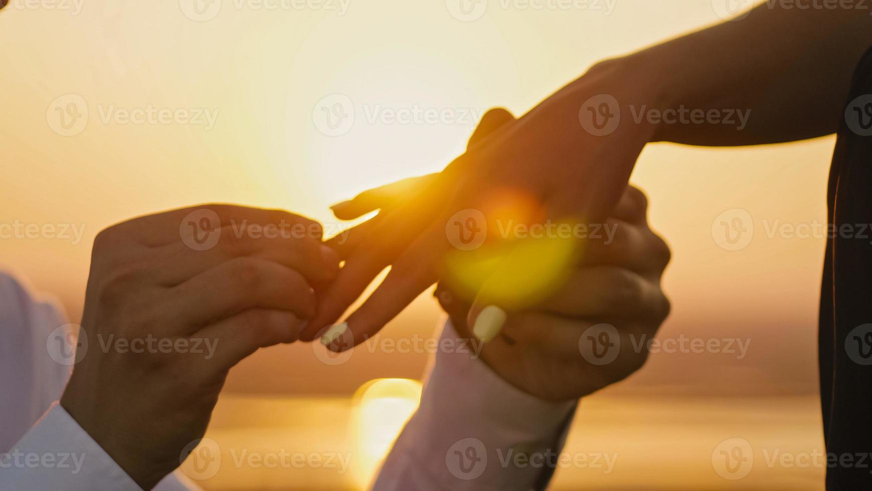 Wedding Ring Put On Finger Hands Touching Sunset Bride Groom Man Woman Marriage Proposal Vacation Honeymoon, horizontal photo