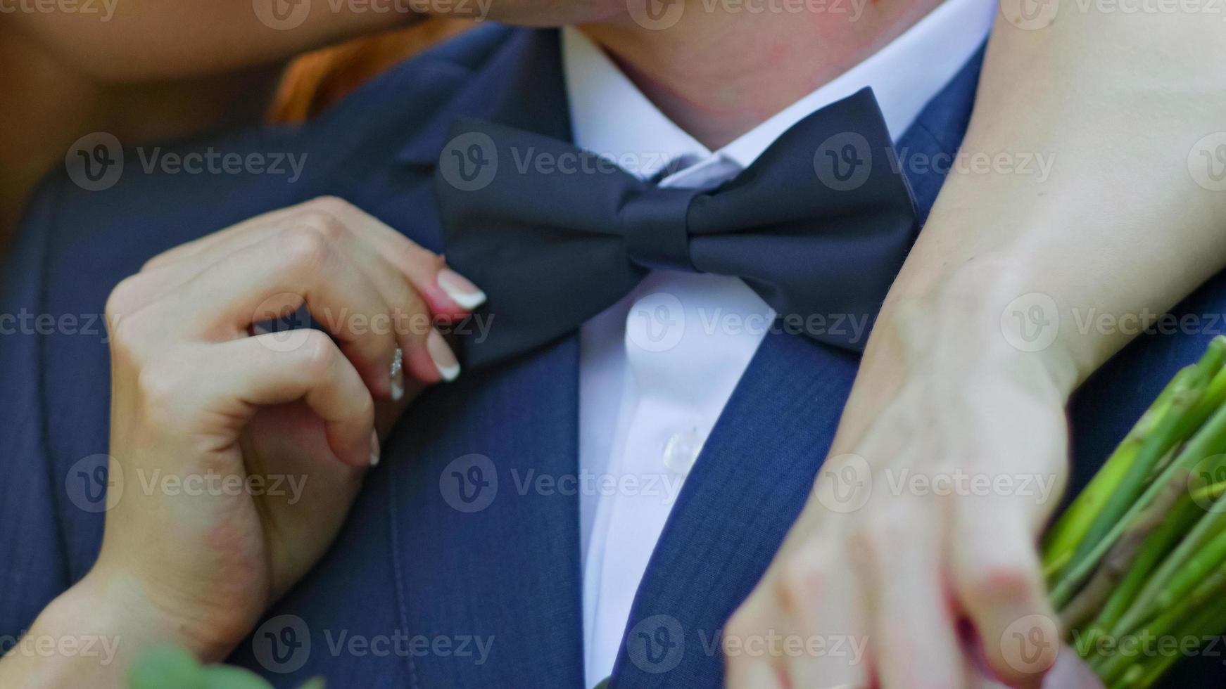 la novia y el novio jóvenes se besan en un parque soleado, de cerca foto