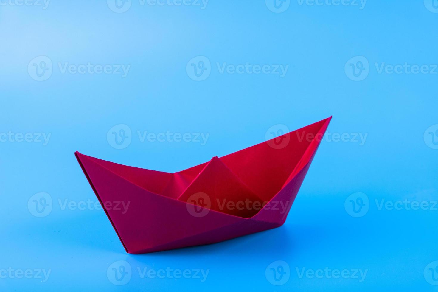 red paper ship in new direction on blue background, New normal concept, copy space photo