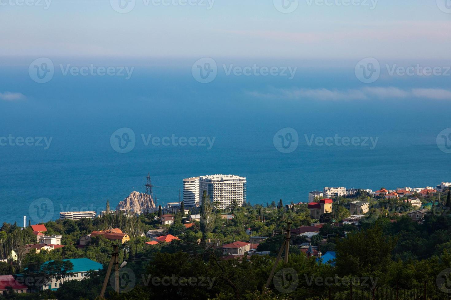 vista de gurzuf desde una colina contra el fondo del mar azul y el cielo. foto