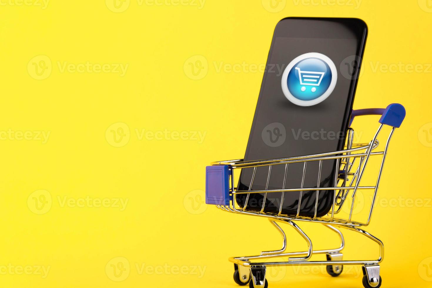 concepto de compras en línea, teléfono y carrito de compras, a la venta con descuento en un fondo amarillo. copie el espacio foto