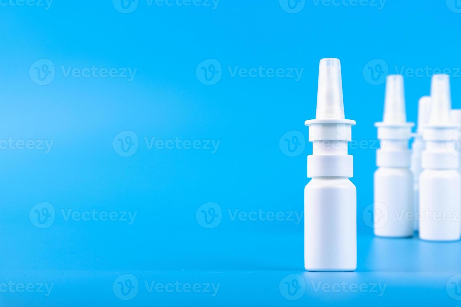 Nasal spray, white plastic bottle on a blue background. Selective focus