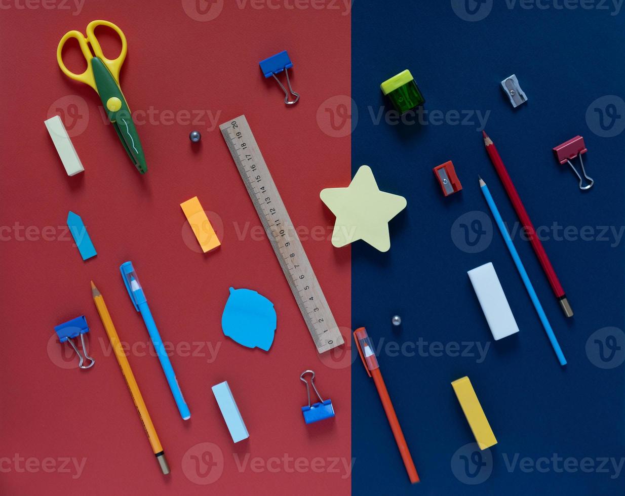 Back to school concept. School and office supplies on the office table. Blue and red background.Flat lay View from above photo