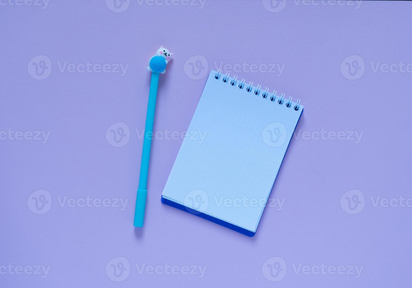 Back to school concept.Notepad and blue pen on a pink background. View from above..Flat lay photo