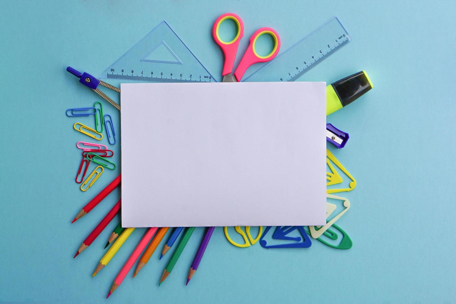 Top view of school supplies and office supplies on blue background. Learning, study, office equipment and presentation concept. photo