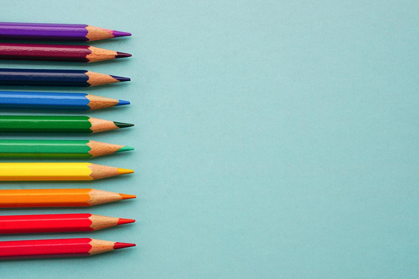 Top view of colored pencils or pastel on blue background. Learning, study and presentation concept. photo