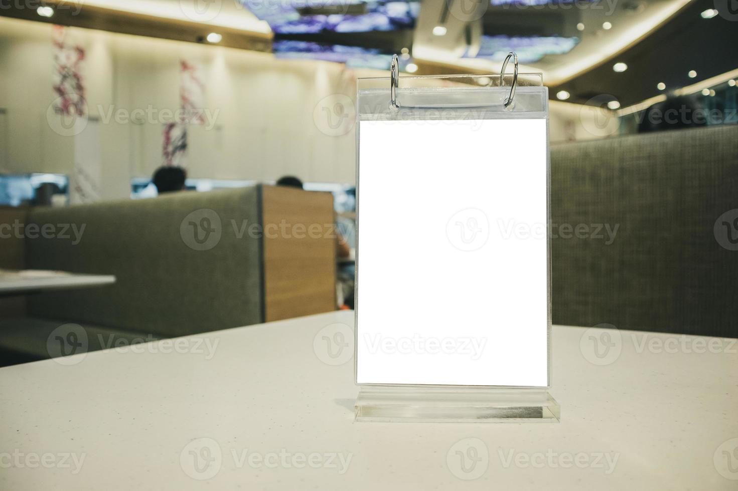 Mockup empty white label menu frame on table with cafe restaurant interior background photo