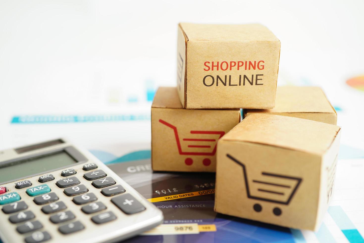 Online shopping, Shopping cart box on calculator, import export, finance commerce. photo