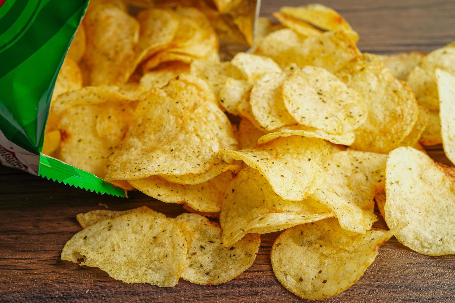 Potato chips in open bag, delicious BBQ seasoning spicy for crips, thin slice deep fried snack fast food in open bag. photo