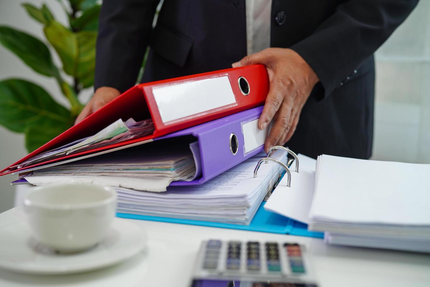 el empresario trabaja y prepara los datos del informe de papeleo para analizar la información en la carpeta de archivos en la oficina. foto