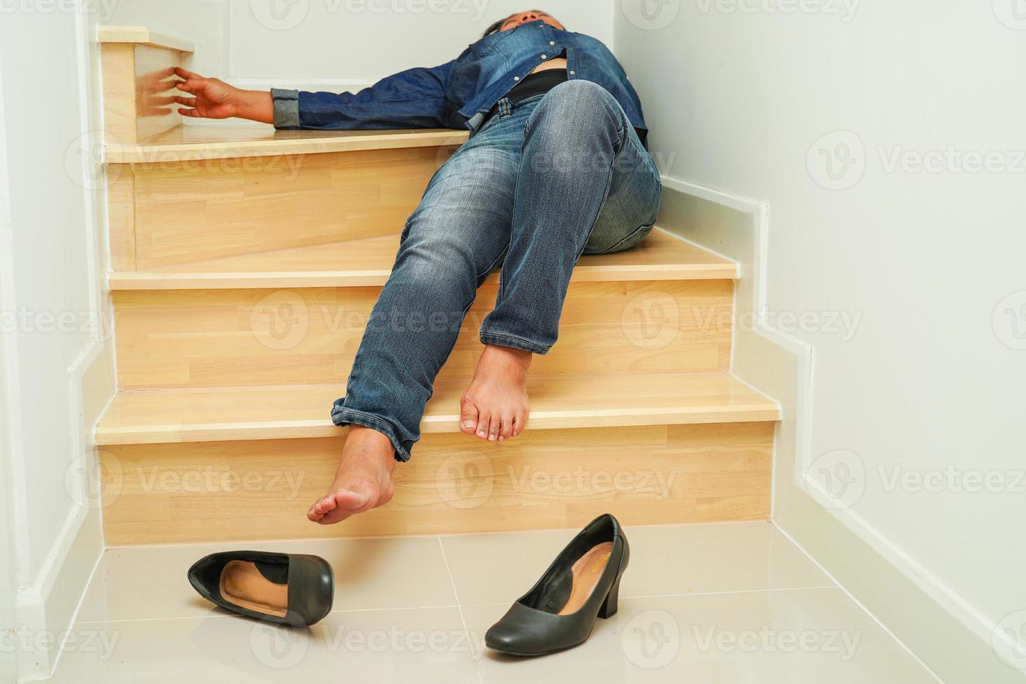 mujer de negocios asiática dolor tobillo, pie con calambres en las piernas y caída por las escaleras porque las superficies resbaladizas en la oficina. foto