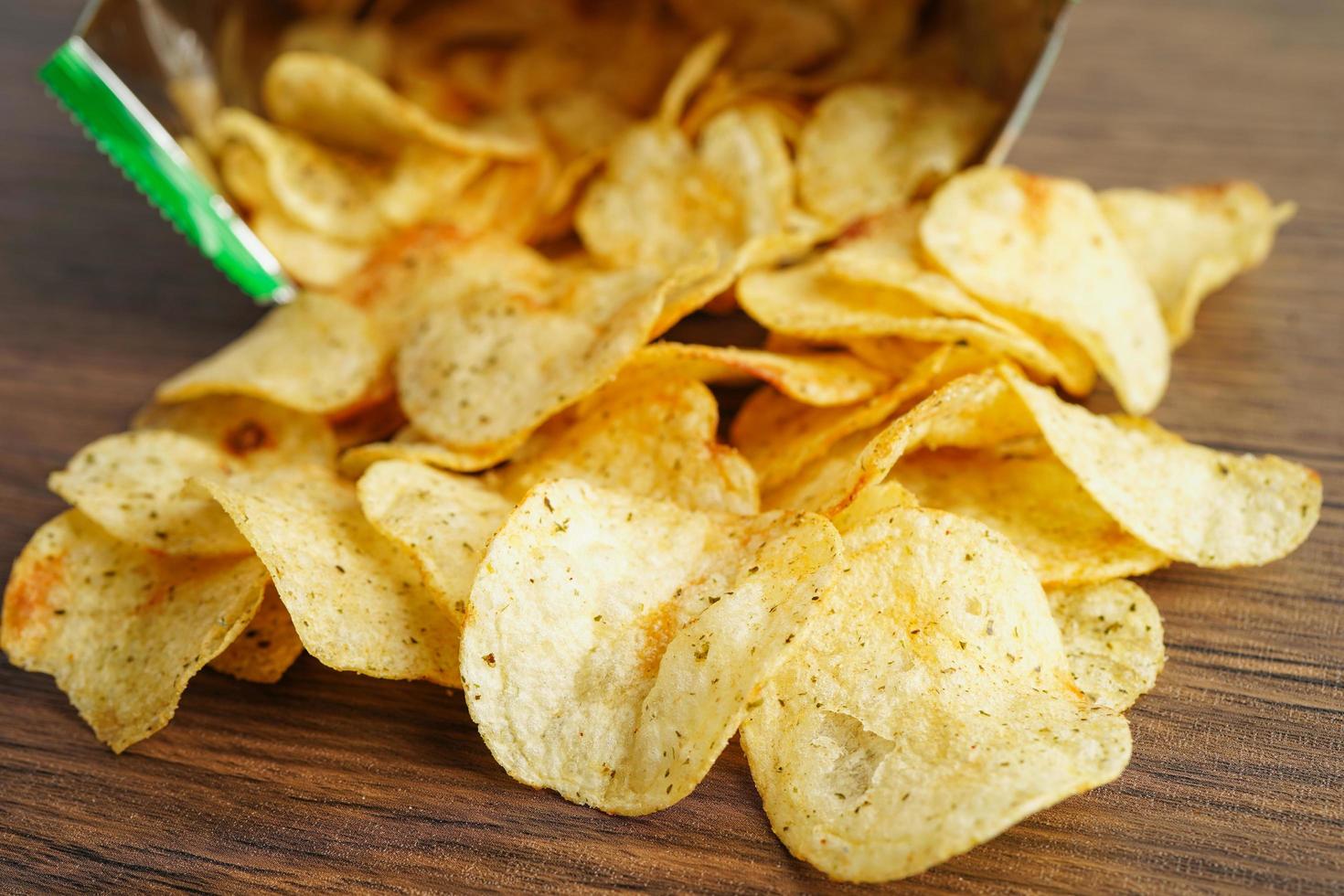 Potato chips in open bag, delicious BBQ seasoning spicy for crips, thin slice deep fried snack fast food in open bag. photo