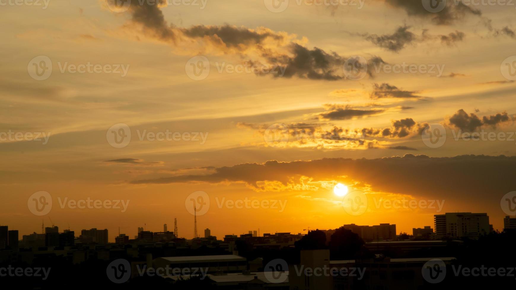 Gives a warm feeling,sunset behind the city building,silhouette city tall buildings,building silhouette again beautiful sky background and freedom concept. photo