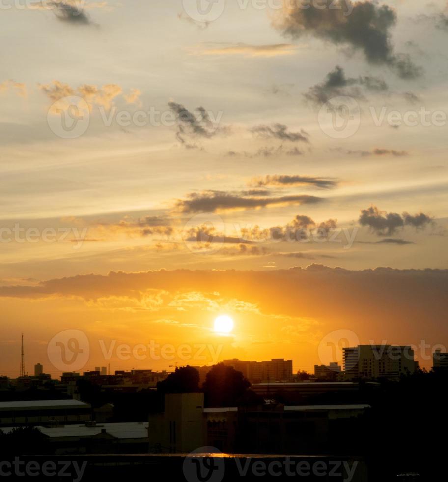 da una sensación cálida, la puesta de sol detrás del edificio de la ciudad, los edificios altos de la ciudad de la silueta, la silueta del edificio de nuevo el hermoso fondo del cielo y el concepto de libertad. foto