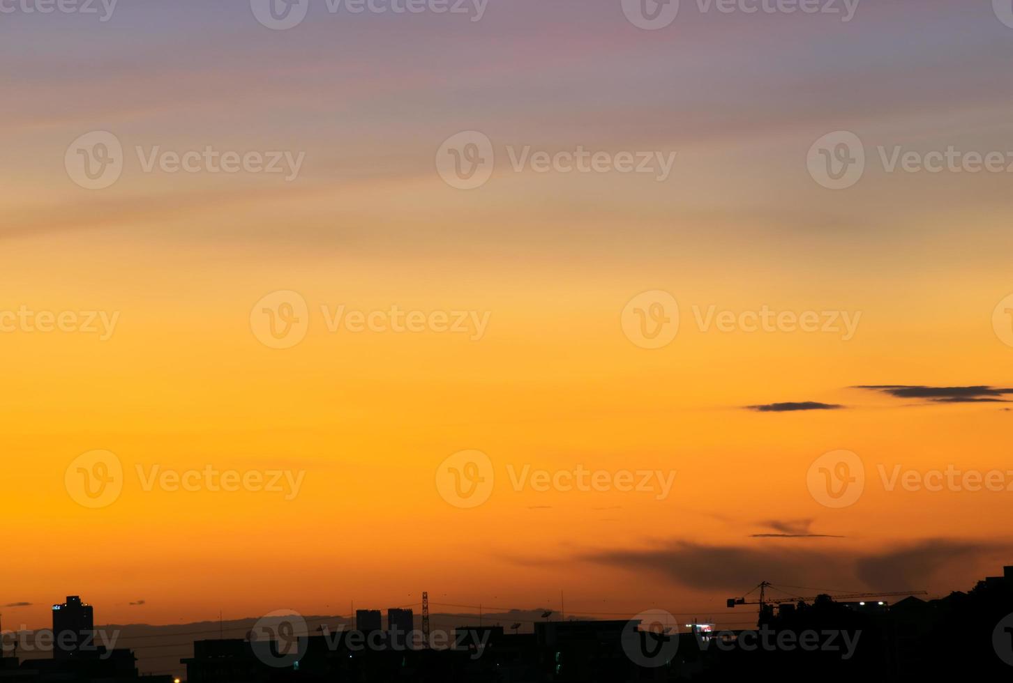 Gives a warm feeling,sunset behind the city building,silhouette city tall buildings,building silhouette again beautiful sky background and freedom concept. photo