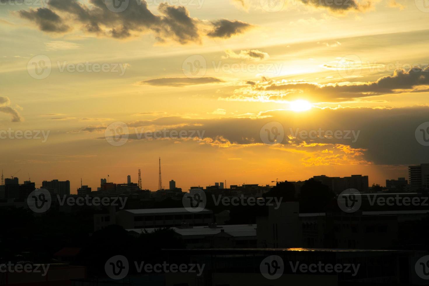 Gives a warm feeling,sunset behind the city building,silhouette city tall buildings,building silhouette again beautiful sky background and freedom concept. photo