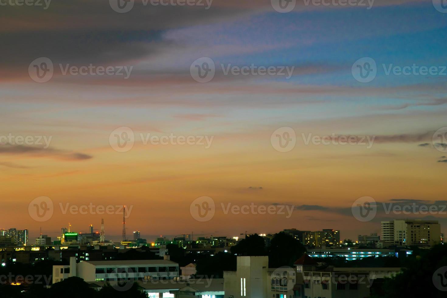 Gives a warm feeling,sunset behind the city building,silhouette city tall buildings,building silhouette again beautiful sky background and freedom concept. photo