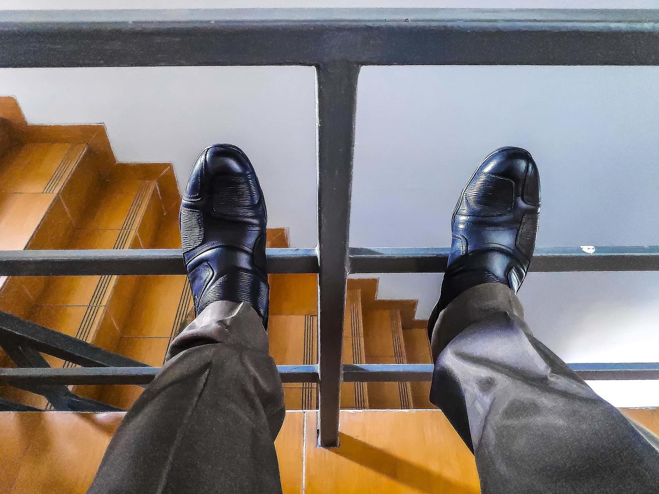 Image of the legs of a men with black shoes photo