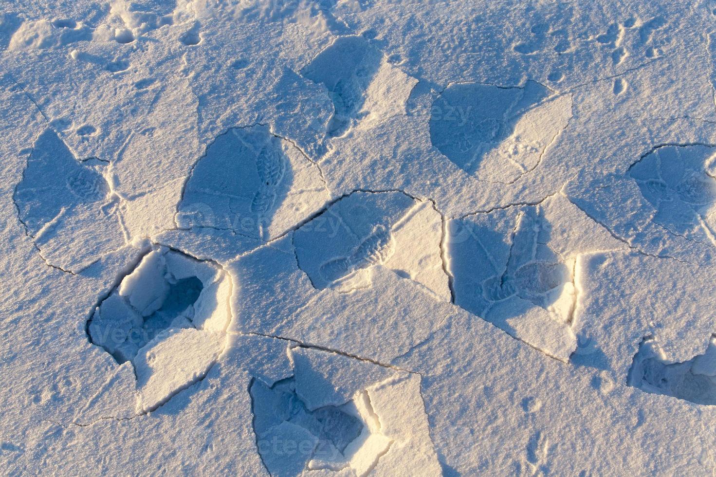 footprints and dents in the snow photo