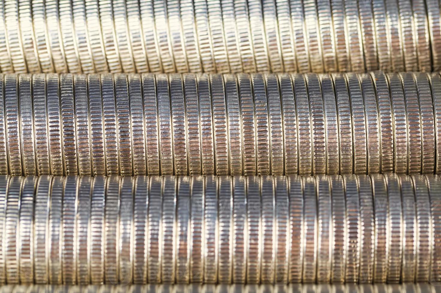 many round metal coins of silver color illuminated in red photo