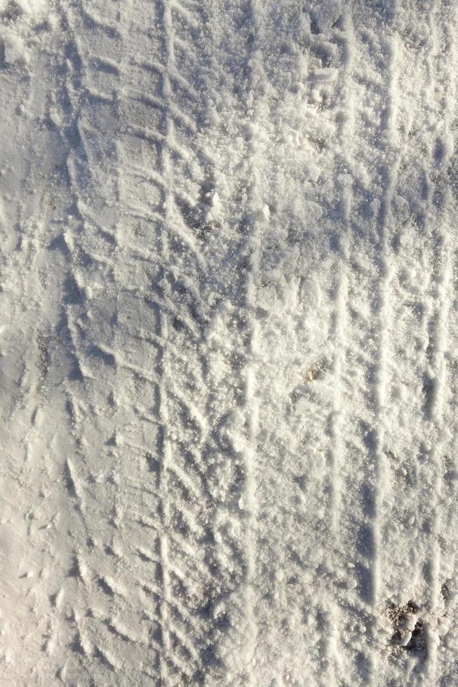 the imprint of the car wheels on snow close up photo